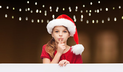 Image showing girl in santa hat with board making hush gesture 