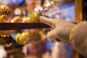 Image showing hand pointing at christmas toys behind shop window