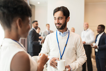 Image showing business people with conference badges and coffee