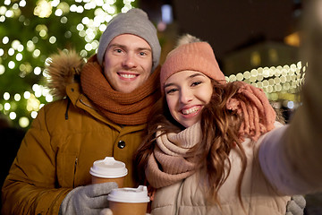 Image showing couple with coffee taking selfie at christmas