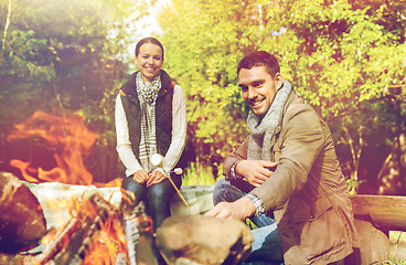 Image showing happy couple roasting marshmallow over camp fire