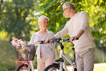 Image showing happy senior couple with bicycles at summer park