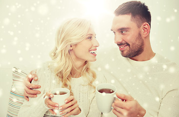 Image showing happy couple with cups drinking tea at home