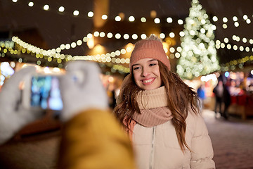 Image showing happy woman posing for smartphone at christmas