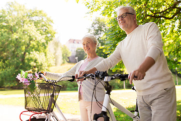 Image showing happy senior couple with bicycles at summer park