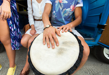 Image showing close up of hippie friends playing tom-tom drum