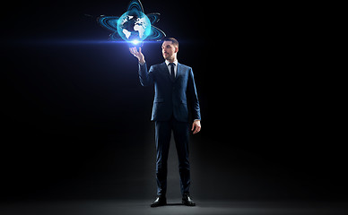 Image showing businessman with earth hologram over black