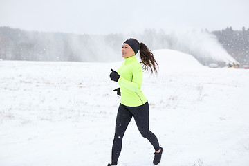 Image showing happy smiling woman running outdoors in winter