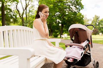 Image showing mother with stroller calling on smartphone at park