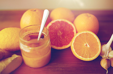 Image showing honey, citrus fruits, ginger and garlic on wood