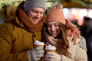 Image showing happy couple with coffee over christmas lights