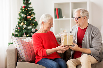 Image showing happy smiling senior couple with christmas gift