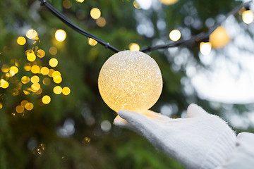 Image showing close up of hand with christmas tree garland bulb