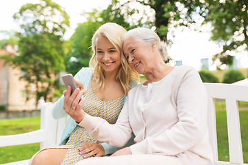 Image showing daughter and senior mother with smartphone at park