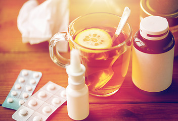 Image showing cup of tea, drugs, honey and paper tissue on wood