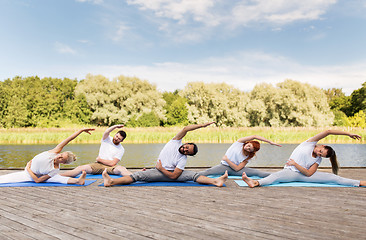 Image showing group of people making yoga exercises outdoors