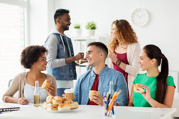 Image showing happy friends or team eating at office party