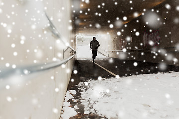 Image showing man running along subway tunnel in winter
