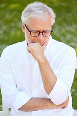 Image showing thoughtful senior man sitting at summer park