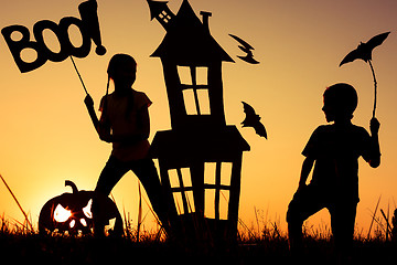 Image showing Happy brother and  sister playing outdoors at the sunset time.