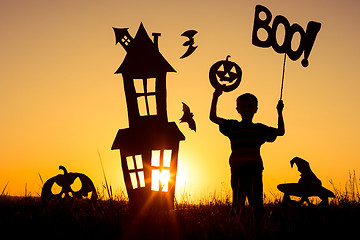 Image showing Happy little boy playing outdoors at the sunset time.