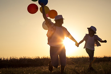 Image showing Father and son running on the road at the sunset time.