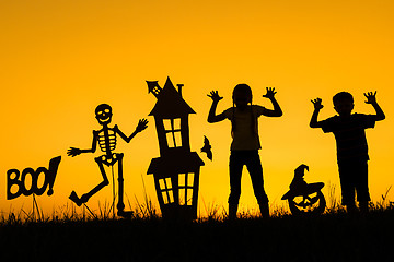 Image showing Happy brother and  sister playing outdoors at the sunset time.