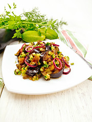 Image showing Salad from eggplant and cucumber with onion in plate on board