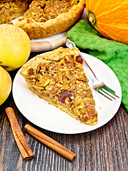 Image showing Pie with pumpkin and apples in plate on dark board