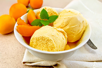 Image showing Ice cream apricot in bowl with spoon on napkin