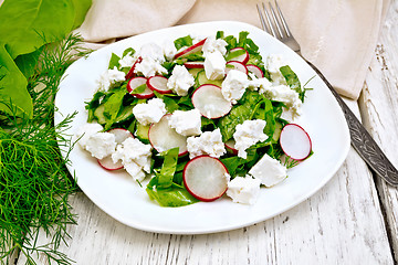 Image showing Salad with spinach and radish in plate on light board