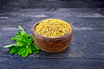 Image showing Fenugreek in clay bowl with green leaf on board