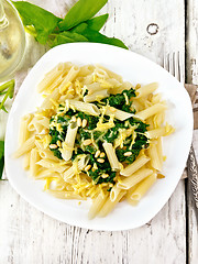 Image showing Pasta penne with spinach and nuts on light board top