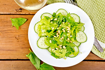 Image showing Salad from spinach and cucumber with lettuce on board top