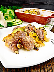 Image showing Meatballs with zucchini and nuts in plate on darkt board