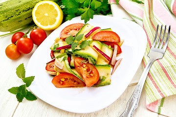 Image showing Salad with zucchini and tomato in plate on light board