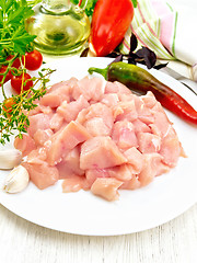 Image showing Chicken breast raw sliced in plate with vegetables on light boar