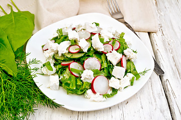 Image showing Salad with cheese and radishes in plate on light board