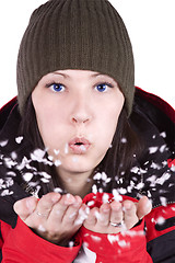 Image showing Woman blowing soft white flakes