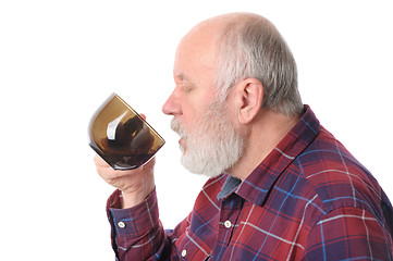 Image showing senior man drinking from cup, isolated on white