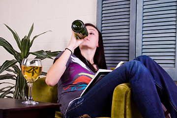 Image showing Cute Girl Drinking while Reading a Book