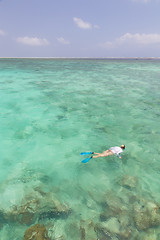 Image showing Woman snorkeling in clear shallow sea of tropical lagoon with turquoise blue water.
