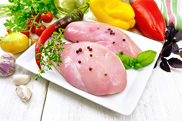 Image showing Chicken breast raw in plate with vegetables and spices on table