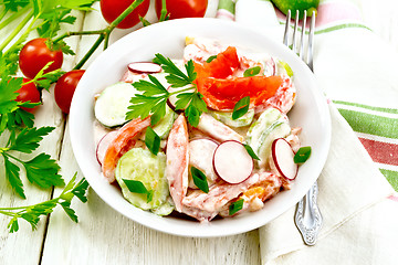 Image showing Salad from fresh vegetables with greens in plate on light board