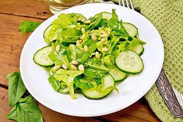 Image showing Salad from spinach and cucumbers with fork on table