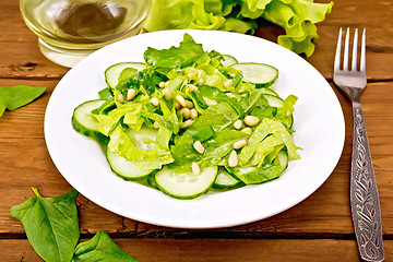 Image showing Salad from spinach and cucumbers with lettuce on table