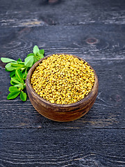 Image showing Fenugreek with green leaf in clay bowl on wooden board