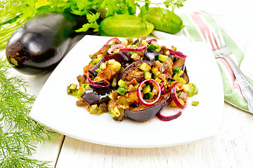 Image showing Salad from eggplant and cucumber with red onion in plate on ligh
