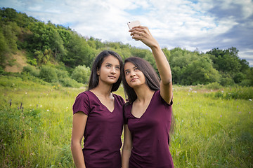 Image showing Beautiful young twins girls doing selfie