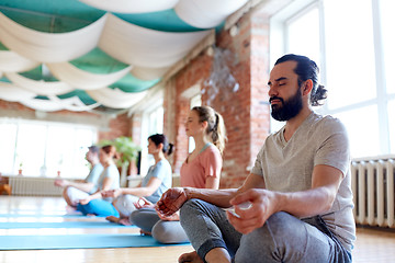 Image showing man with group of people meditating at yoga studio